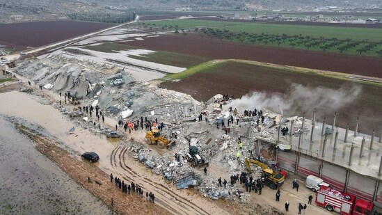 The aerial view shows residents helped by bulldozers, searching for victims and survivors in the rubble of collapsed buildings in the northwestern Syrian Idlib province,&nbsp;(AFP)