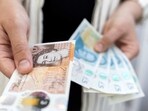 UK Digital Currency: Woman holds British Pound banknotes.