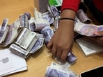 A shop assistant counts piles of British Pound Sterling banknotes at an Apple store in London, Britain.