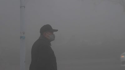 China Heavy Fog Warning: A man wearing a mask stands amid heavy fog in Jinan, Shandong province, China. (Reuters)
