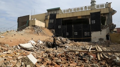 A man walks amid the rubble, days after a suicide blast in a mosque in Peshawar, (REUTERS)