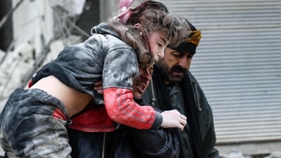 Residents carry an injured child from the rubble of a collapsed building following an earthquake in Jandaris in Syria. (AFP) Residents carry an injured child from the rubble of a collapsed building following an earthquake in Jandaris in Syria. (AFP)