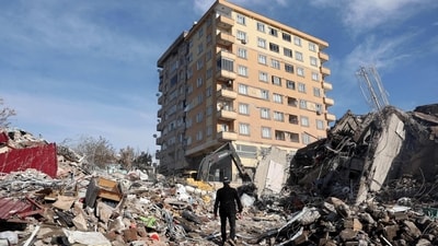 A man walks across the rubble of collapsed building towards a building still standing s in Kahramanmaras, (AFP) A man walks across the rubble of collapsed building towards a building still standing s in Kahramanmaras, (AFP)