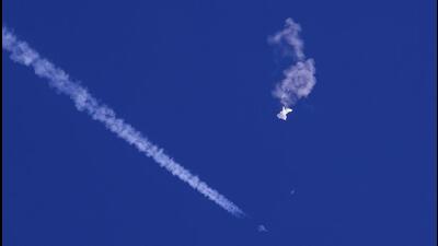 The remnants of a large balloon drift above the Atlantic Ocean, just off the coast of South Carolina, with a fighter jet and its contrail seen below it, on Saturday. (AP) The remnants of a large balloon drift above the Atlantic Ocean, just off the coast of South Carolina, with a fighter jet and its contrail seen below it, on Saturday. (AP)