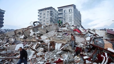 People walk amid rubble following an earthquake in Hatay, Turkey, Tuesday. (REUTERS)