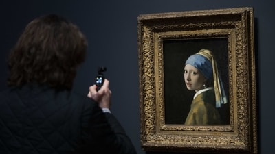 Considered to be Vermeer's most famous painting, “Girl with a Pearl Earring” seen at the Vermeer exhibit at Amsterdam's Rijksmuseum, on February 6. Starting February 10, the exhibition will unveil a blockbuster collection of 28 paintings by the 17th-century Dutch artist drawn from galleries around the world. (Peter Dejong / AP ) Considered to be Vermeer's most famous painting, “Girl with a Pearl Earring” seen at the Vermeer exhibit at Amsterdam's Rijksmuseum, on February 6. Starting February 10, the exhibition will unveil a blockbuster collection of 28 paintings by the 17th-century Dutch artist drawn from galleries around the world. (Peter Dejong / AP )