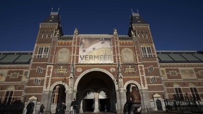 People seen passing under the Vermeer exhibit sign at Amsterdam's Rijksmuseum, on February 6. Netherland's national museum of art and history brings together 28 of Vermeer's paintings from seven countries- considerably a historic feat, since only 37 paintings are generally ascribed to the artist who lived from 1632-1675 in the city of Delft. (Peter Dejong / AP ) People seen passing under the Vermeer exhibit sign at Amsterdam's Rijksmuseum, on February 6. Netherland's national museum of art and history brings together 28 of Vermeer's paintings from seven countries- considerably a historic feat, since only 37 paintings are generally ascribed to the artist who lived from 1632-1675 in the city of Delft. (Peter Dejong / AP )