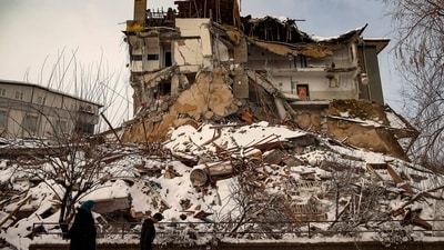 People walk past a collapsed building in Malatya, Turkey. (AP) People walk past a collapsed building in Malatya, Turkey. (AP)