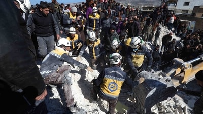 Syrian White Helmet rescuers and residents recover a body from the rubble of a destroyed building in the village of Azmarin in Syria's rebel-held northwestern Idlib province. (AFP)