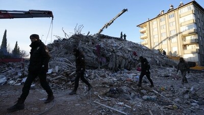 Policemen walk in front of a collapsed building in Gaziantep, southeastern Turkey, Wednesday, Feb. 8, 2023. Thinly stretched rescue teams worked through the night into Wednesday, pulling more bodies from the rubble of thousands of buildings downed in Turkey and Syria by a catastrophic earthquake. (AP Photo/Kamran Jebreili) (AP)