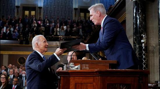 US President Joe Biden (left) hands a copy of his speech to House Speaker Kevin McCarthy of California, before he delivers his State of the Union address to a joint session of Congress, at the Capitol in Washington, US, on Tuesday. (REUTERS)