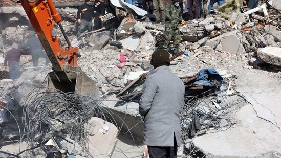 A man looks as rescuers and civilians look for survivors under the rubble of collapsed buildings in Kahramanmaras, on February 8, 2023. (AFP)