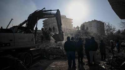 People stand among the rubble of collapsed buildings during search operations in Kahramanmaras, on February 9, 2023, three days after a 7,8-magnitude earthquake struck southeast Turkey. - The death toll from a huge earthquake that hit Turkey and Syria climbed to more than 17,100 on on February 9, as hopes faded of finding survivors stuck under rubble in freezing weather. (Photo by OZAN KOSE / AFP) (AFP) People stand among the rubble of collapsed buildings during search operations in Kahramanmaras, on February 9, 2023, three days after a 7,8-magnitude earthquake struck southeast Turkey. - The death toll from a huge earthquake that hit Turkey and Syria climbed to more than 17,100 on on February 9, as hopes faded of finding survivors stuck under rubble in freezing weather. (Photo by OZAN KOSE / AFP) (AFP)