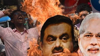 A Congress party activist burns an effigy of PM Modi and Gautam Adani during a protest rally in Kolkata on Monday. (AFP) A Congress party activist burns an effigy of PM Modi and Gautam Adani during a protest rally in Kolkata on Monday. (AFP)