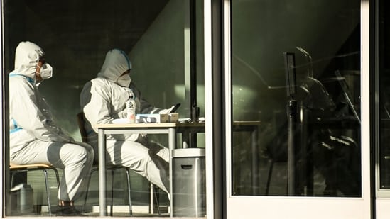 Covid In China: Security guards wearing personal protective equipment (PPE) amid the Covid-19 pandemic sit at an entrance of a building in Beijing. (AFP)