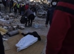 People stand around a dead body taken out from the rubble of a destroyed building in Antakya, southern Turkey, on Thursday, (AP) People stand around a dead body taken out from the rubble of a destroyed building in Antakya, southern Turkey, on Thursday, (AP)