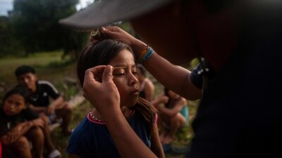 A Siekopai indigenous girl seen getting face makeup done during the second binational meeting of the Siekopai Nation community, in Lagartococha, on January 10. The children wear jeans, T-shirts and sneakers, listen to reggaeton and, instead of learning to fish, hunt and make traditional plant brews when not in school. The Siekopai youth, said Sophie Pinchetti of the non-governmental organization Amazon Frontlines, "live in a complex reality: one foot in the modern, Western world and the other in their territory." (Pedro Pardo / AFP) A Siekopai indigenous girl seen getting face makeup done during the second binational meeting of the Siekopai Nation community, in Lagartococha, on January 10. The children wear jeans, T-shirts and sneakers, listen to reggaeton and, instead of learning to fish, hunt and make traditional plant brews when not in school. The Siekopai youth, said Sophie Pinchetti of the non-governmental organization Amazon Frontlines, "live in a complex reality: one foot in the modern, Western world and the other in their territory." (Pedro Pardo / AFP)