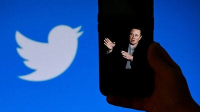 An illustration photo shows a phone screen displaying a photo of Elon Musk with the Twitter logo shown in the background. (AFP)
