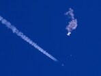 Chinese Spy Balloon: Remnants of a large balloon drift above the Atlantic Ocean, just off the coast of South Carolina, with a fighter jet and its contrail seen. Chinese Spy Balloon: Remnants of a large balloon drift above the Atlantic Ocean, just off the coast of South Carolina, with a fighter jet and its contrail seen.