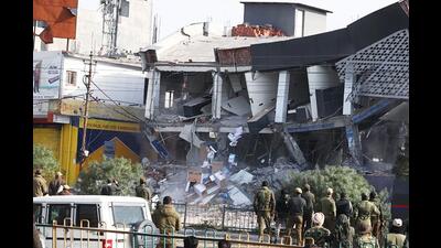 Security personnel deployed outside an automobile showroom, which is being demolished during an anti-Security personnel deployed outside an automobile showroom, which is being demolished during an anti-encroachment drive, in Jammu on Saturday. (ANI)
