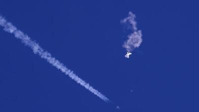 The remnants of a large balloon drift above the Atlantic Ocean, just off the coast of South Carolina, US, with a fighter jet and its contrail seen below it, on February 4, 2023. (AP) The remnants of a large balloon drift above the Atlantic Ocean, just off the coast of South Carolina, US, with a fighter jet and its contrail seen below it, on February 4, 2023. (AP)