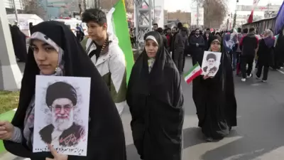 Iranian demonstrators carry posters of the Supreme Leader Ayatollah Ali Khamenei and their national flag during the annual rally commemorating Iran's 1979 Islamic Revolution, in Tehran, Iran (AP) Iranian demonstrators carry posters of the Supreme Leader Ayatollah Ali Khamenei and their national flag during the annual rally commemorating Iran's 1979 Islamic Revolution, in Tehran, Iran (AP)