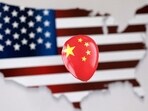 Chinese Spy Balloon: A printed balloon with Chinese flag is placed on a US flag in the shape of US map outline, in this illustration.