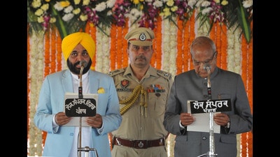 Chandigarh, India March 16: Bhagwant Mann Aam Aadmi Party (AAP) candidate in Punjab's state assembly polls takes the oath as Chief Minister of Punjab next to Punjab's governor Banwarilal Purohit during the swearing-in ceremony at Khatkar Kalan village of Punjab on March 16, 2022. Photo by Ravi Kumar/Hindustan Times Chandigarh, India March 16: Bhagwant Mann Aam Aadmi Party (AAP) candidate in Punjab's state assembly polls takes the oath as Chief Minister of Punjab next to Punjab's governor Banwarilal Purohit during the swearing-in ceremony at Khatkar Kalan village of Punjab on March 16, 2022. Photo by Ravi Kumar/Hindustan Times