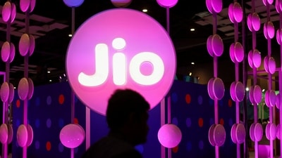 A man walks across the LED board showing the logo of Jio. (REUTERS)