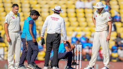 Australia's captain Pat Cummins, right, looks on as groundsmen work on the pitch during the second day of the first cricket test match (AP) Australia's captain Pat Cummins, right, looks on as groundsmen work on the pitch during the second day of the first cricket test match (AP)