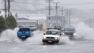 Cars move through flooded roads in the northern New Zealand city of Whangarei as Tropical Cyclone Gabrielle hits the Northland. (AP)