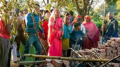 Villagers outside the rubble of a house during an anti-encroachment drive, in Kanpur Dehat on Monday. (PTI Photo)