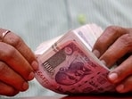 A man counts Indian currency notes inside a shop in Mumbai. The Indian rupee on Thursday had closed at 71.03 against the US dollar. A man counts Indian currency notes inside a shop in Mumbai. The Indian rupee on Thursday had closed at 71.03 against the US dollar.