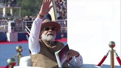 PM Narendra Modi waving at passing Indian Light Combat helicopters at AERO 2023. PM Narendra Modi waving at passing Indian Light Combat helicopters at AERO 2023.