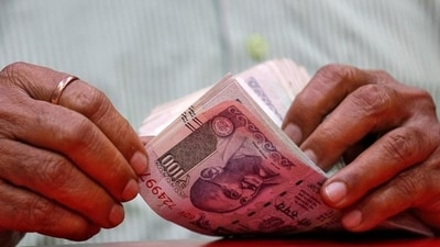 A man counts Indian currency notes inside a shop in Mumbai. The Indian rupee on Thursday had closed at 71.03 against the US dollar. (REUTERS) A man counts Indian currency notes inside a shop in Mumbai. The Indian rupee on Thursday had closed at 71.03 against the US dollar. (REUTERS)