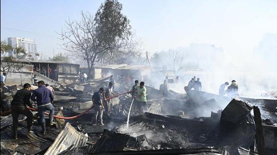 Gurugram, India-February 14, 2023: Fire fighters trying to douse off fire gutted inside a slum area at Ghasola village sector-49 near Uppal Southend society in Gurugram, India, on Tuesday, 14 February 2023. More than 100 Jhuggis gutted in fire due to an unknown reason (Photo by Parveen Kumar/Hindustan Times)