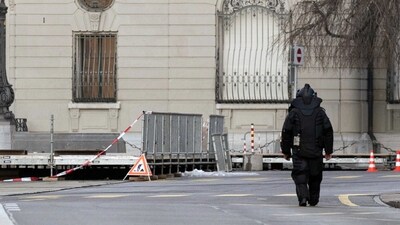 Switzerland Bomb Scare: An explosives expert walks in front of the Swiss Parliament, the Bundeshaus, during the large-scale operation of the Bern police. (AP)