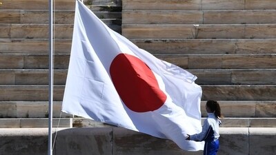 An athlete adjusts the Japanese flag. (File image) (AP) An athlete adjusts the Japanese flag. (File image) (AP)