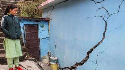 A resident shows cracks that appeared in her house at Sunil Village in Joshimath. (PTI) A resident shows cracks that appeared in her house at Sunil Village in Joshimath. (PTI)