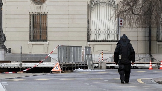 Switzerland Bomb Scare: An explosives expert walks in front of the Swiss Parliament, the Bundeshaus, during the large-scale operation of the Bern police. (AP)