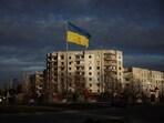 A Ukrainian national flag flutters near the buildings destroyed by Russian military strike in Kyiv.