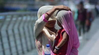 Thane, India - May 02, 2022: A mother shields her child and herself with her saree in the sweltering heat as the mercury rises, in Thane, Mumbai, India, on Monday, May 02, 2022. (Praful Gangurde/HT Photo) (HT PHOTO)