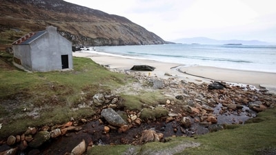 A view of the fisherman's cottage used in the film as the home for Brendan Gleeson's character. Between July and November 2021, Achill Island's dramatic landscape of rugged cliffs, peat bogs, and sandy beaches was transformed. "They couldn't create this in the studio," Chris McCarthy, the manager of Achill Tourism, told AFP, adding that the director, Martin McDonagh, wanted the actors “to feel the atmosphere of the Atlantic”. (Paul Faith / AFP) A view of the fisherman's cottage used in the film as the home for Brendan Gleeson's character. Between July and November 2021, Achill Island's dramatic landscape of rugged cliffs, peat bogs, and sandy beaches was transformed. "They couldn't create this in the studio," Chris McCarthy, the manager of Achill Tourism, told AFP, adding that the director, Martin McDonagh, wanted the actors “to feel the atmosphere of the Atlantic”. (Paul Faith / AFP)