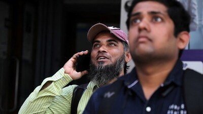 Men react as they look at a screen displaying the Sensex results on the facade of the Bombay Stock Exchange (BSE) building in Mumbai. (REUTERS)
