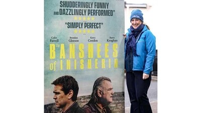An employee of the Achill Island Tourism office seen with a poster of the film ‘The Banshees of Inisherin’, on Achill Island, on January 31. “It's such a lovely place to visit and anyone that ever does visit always falls in love with the place,” film extra Madeline Condell told AFP. (Paul Faith / AFP) An employee of the Achill Island Tourism office seen with a poster of the film ‘The Banshees of Inisherin’, on Achill Island, on January 31. “It's such a lovely place to visit and anyone that ever does visit always falls in love with the place,” film extra Madeline Condell told AFP. (Paul Faith / AFP)
