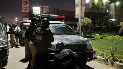 Police officers take position after a police office building was attacked by gunmen in Karachi, Pakistan (Reuters)