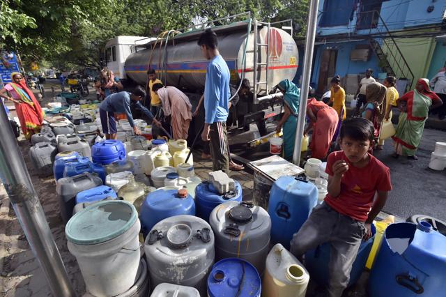 Residents rush to fill water buckets from a NDMC water tanker at Sanjay Camp in New Delhi. (Raj K Raj /Hindustan Times)