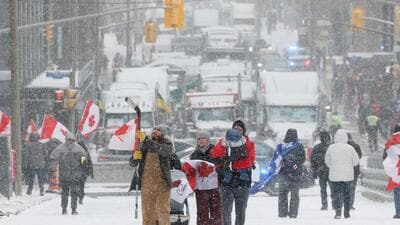 Demonstrators walk downtown as truckers and their supporters continue to protest Covid-19 vaccine mandates, in Ottawa, Ontario, Canada, February 12, 2022. (REUTERS) Demonstrators walk downtown as truckers and their supporters continue to protest Covid-19 vaccine mandates, in Ottawa, Ontario, Canada, February 12, 2022. (REUTERS)