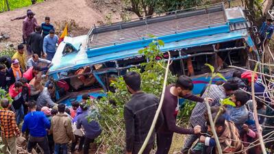 People gather near the bus that plunged into a gorge, in Reasi on Friday. (PTI)