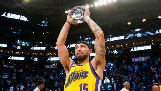 Team Pau Gasol's Jose Alvarado, of the New Orleans Pelicans, holds the MVP trophy after making the game-winning shot in an NBA Rising Stars final basketball game against Team Joakim Noah. (AP)
